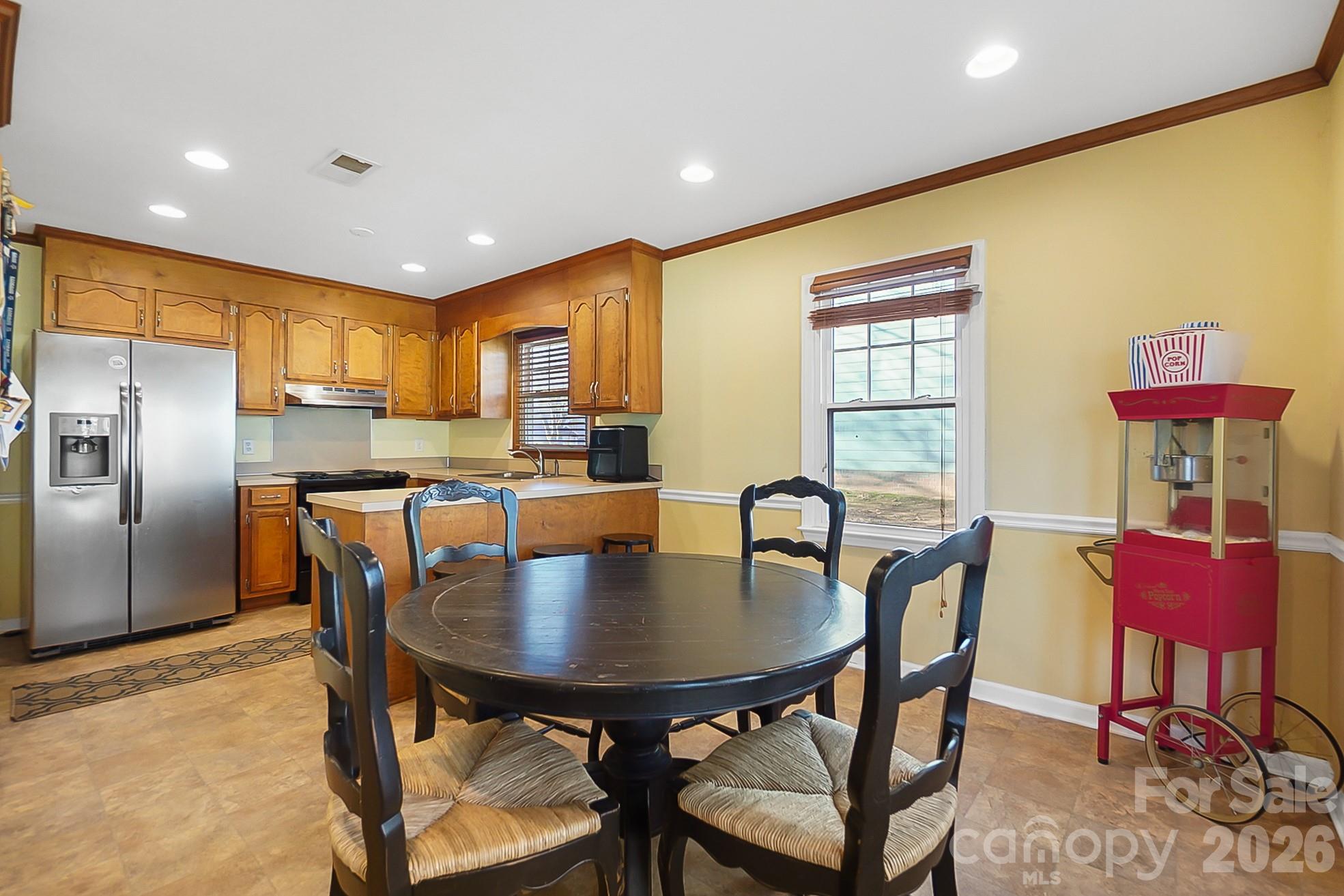 6906 Streamside Drive Charlotte, NC 28212 - Photo 10 of 48 a kitchen with a dining table chairs and refrigerator