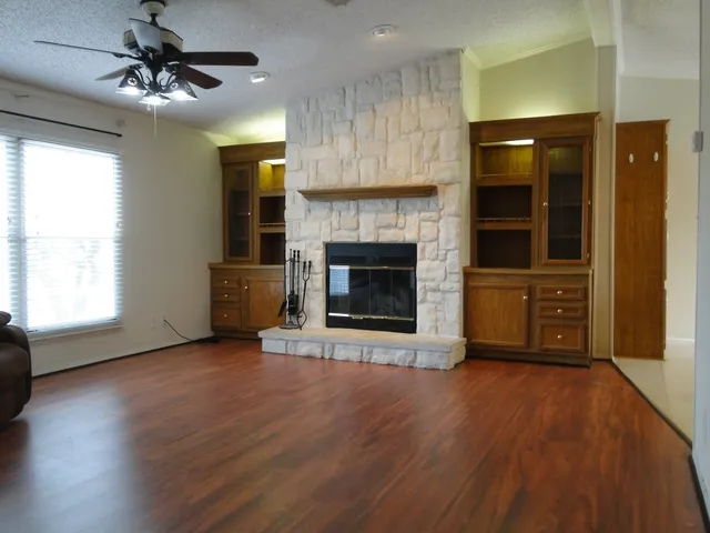 wooden floor fireplace and windows in an empty room