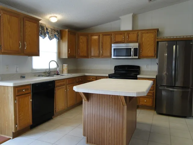 a kitchen with a sink a stove a refrigerator and a microwave