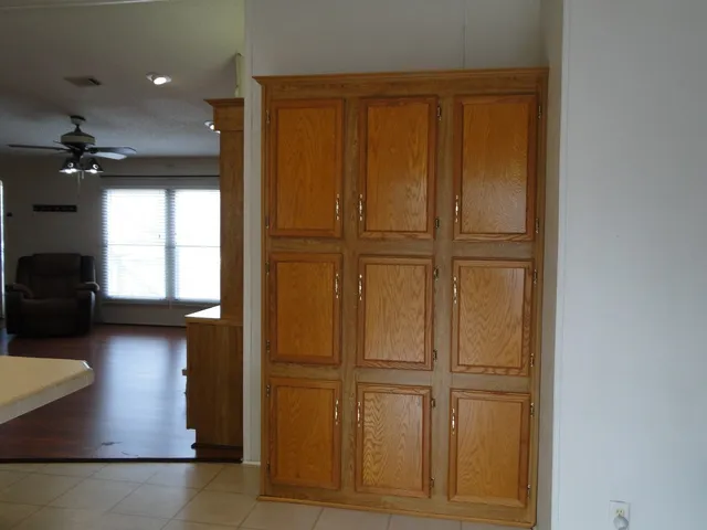 a kitchen with kitchen island granite countertop a refrigerator a sink dishwasher a stove and a dining table with wooden floor