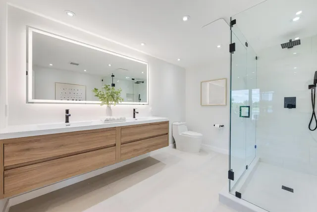 a bathroom with a double vanity sink mirror and shower