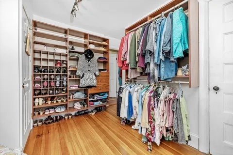 a view of walk in closet with clothes and shoes