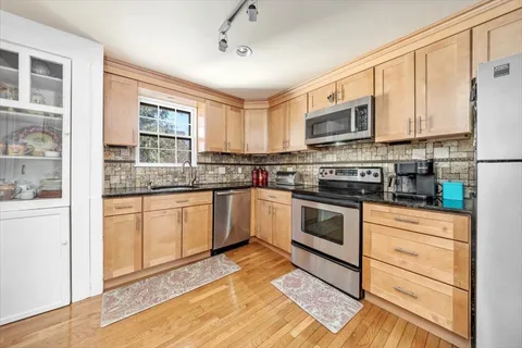 a kitchen with stainless steel appliances granite countertop a stove a sink and a refrigerator