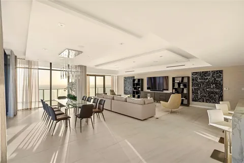 a living room with furniture flat screen tv and a large window