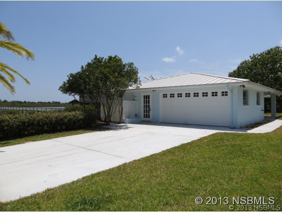 208 Virginia Street Edgewater, FL 32132 - Photo 1 of 15 a front view of a house with a yard and garage