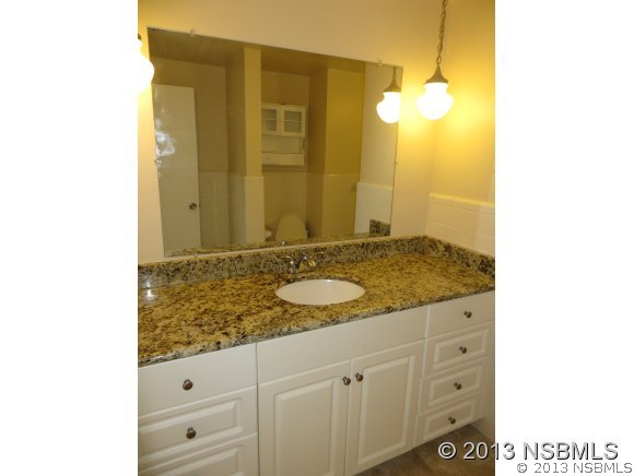 208 Virginia Street Edgewater, FL 32132 - Photo 13 of 15 a bathroom with a granite countertop sink and a mirror