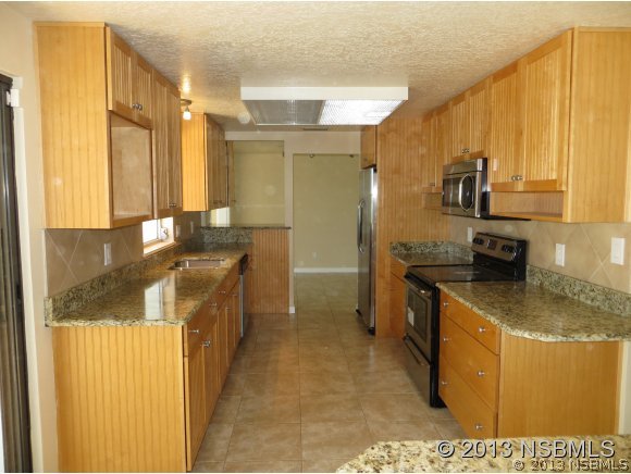 208 Virginia Street Edgewater, FL 32132 - Photo 2 of 15 a kitchen with stainless steel appliances granite countertop a sink a stove and a refrigerator