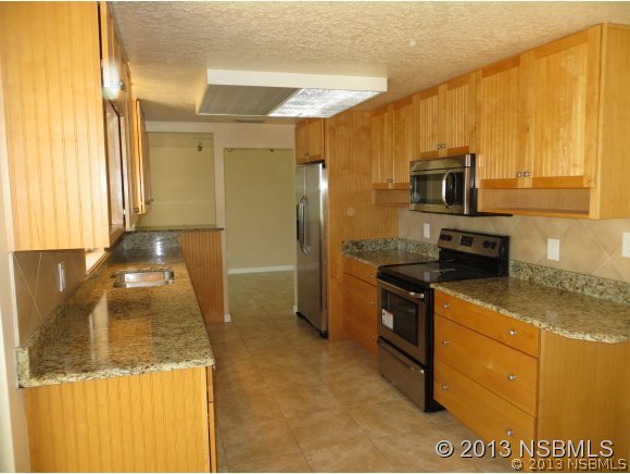 208 Virginia Street Edgewater, FL 32132 - Photo 3 of 15 a kitchen with stainless steel appliances granite countertop a sink a stove and a refrigerator