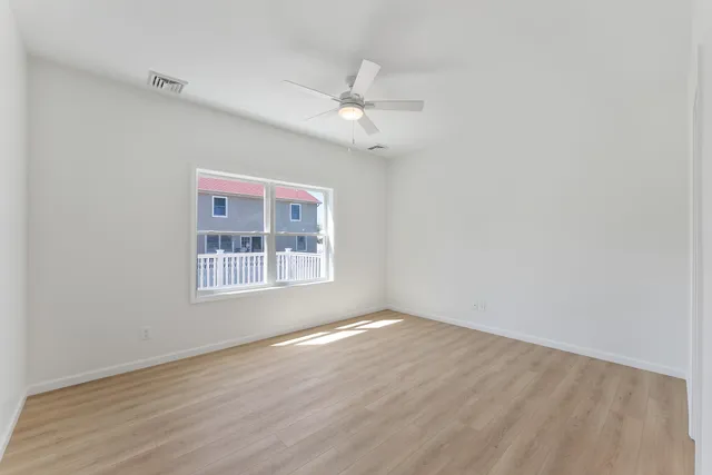a view of a room that has wooden floor and a window