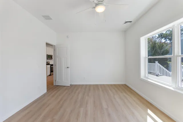 an empty room with a window and wooden floor