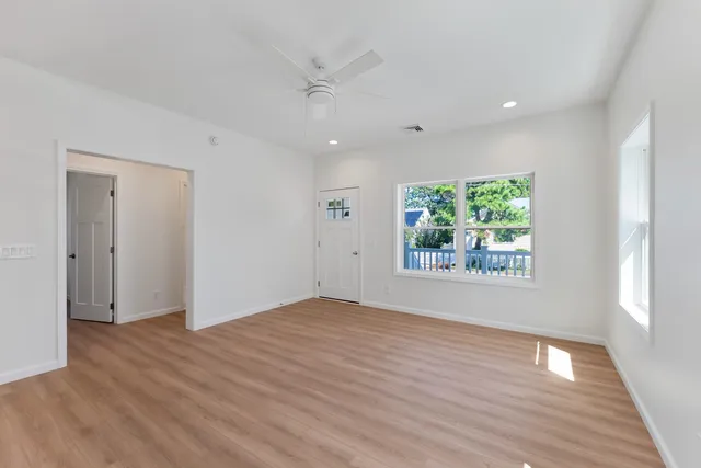 a kitchen with stainless steel appliances granite countertop a refrigerator a stove top oven a sink dishwasher and a refrigerator with wooden floor