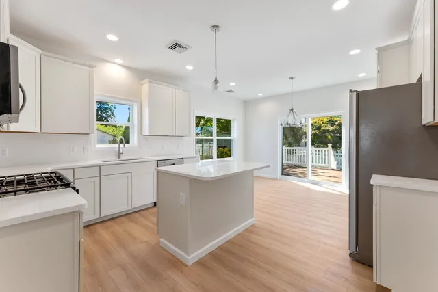 a kitchen with stainless steel appliances a refrigerator and a window