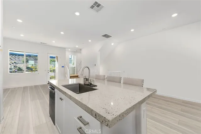 a kitchen with stainless steel appliances granite countertop a sink and a refrigerator