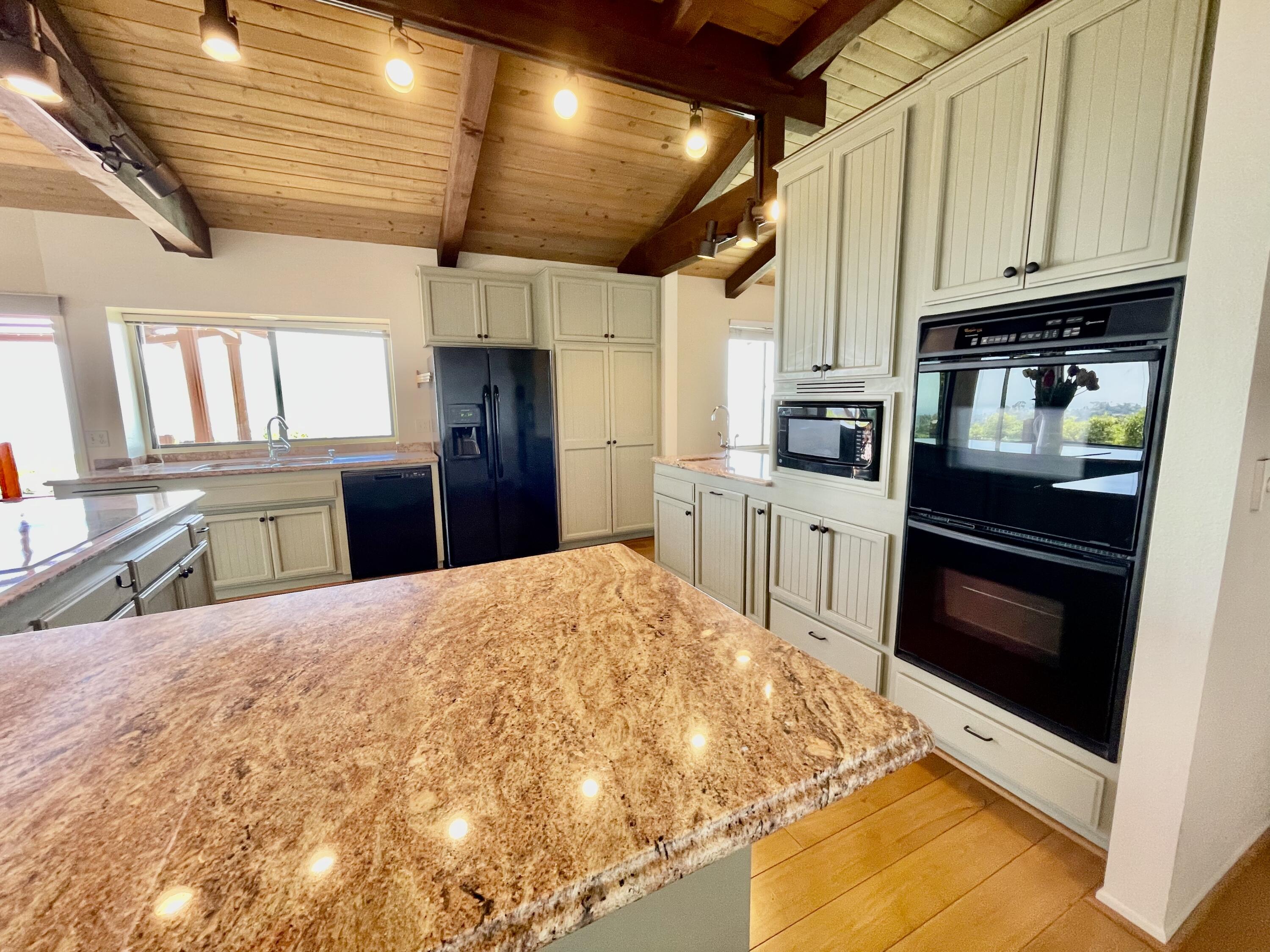 260 Loma Media Road Santa Barbara, CA 93103 - Photo 11 of 23 a kitchen with stainless steel appliances kitchen island granite countertop a stove and a refrigerator