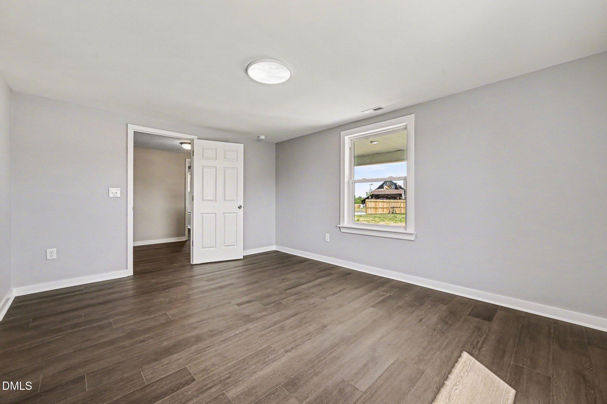 1325 Charlie Carr Road Roxboro, NC 27574 - Photo 25 of 31 an empty room with wooden floor and windows