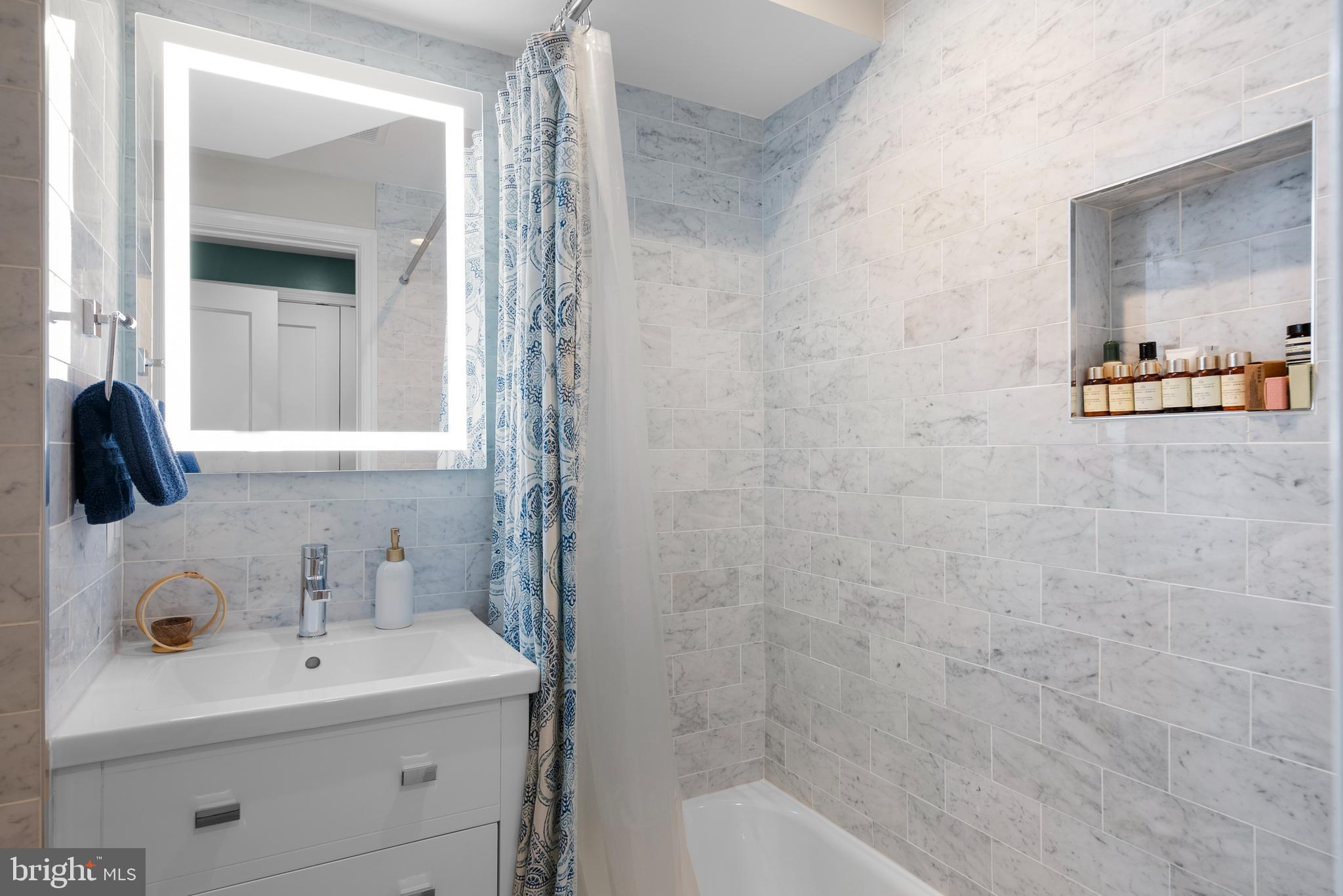 1663 32nd Street Northwest Washington, DC 20007 - Photo 9 of 38 a bathroom with a sink a mirror and shower
