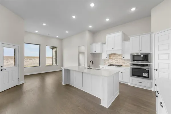 a kitchen with stainless steel appliances a sink stove and cabinets