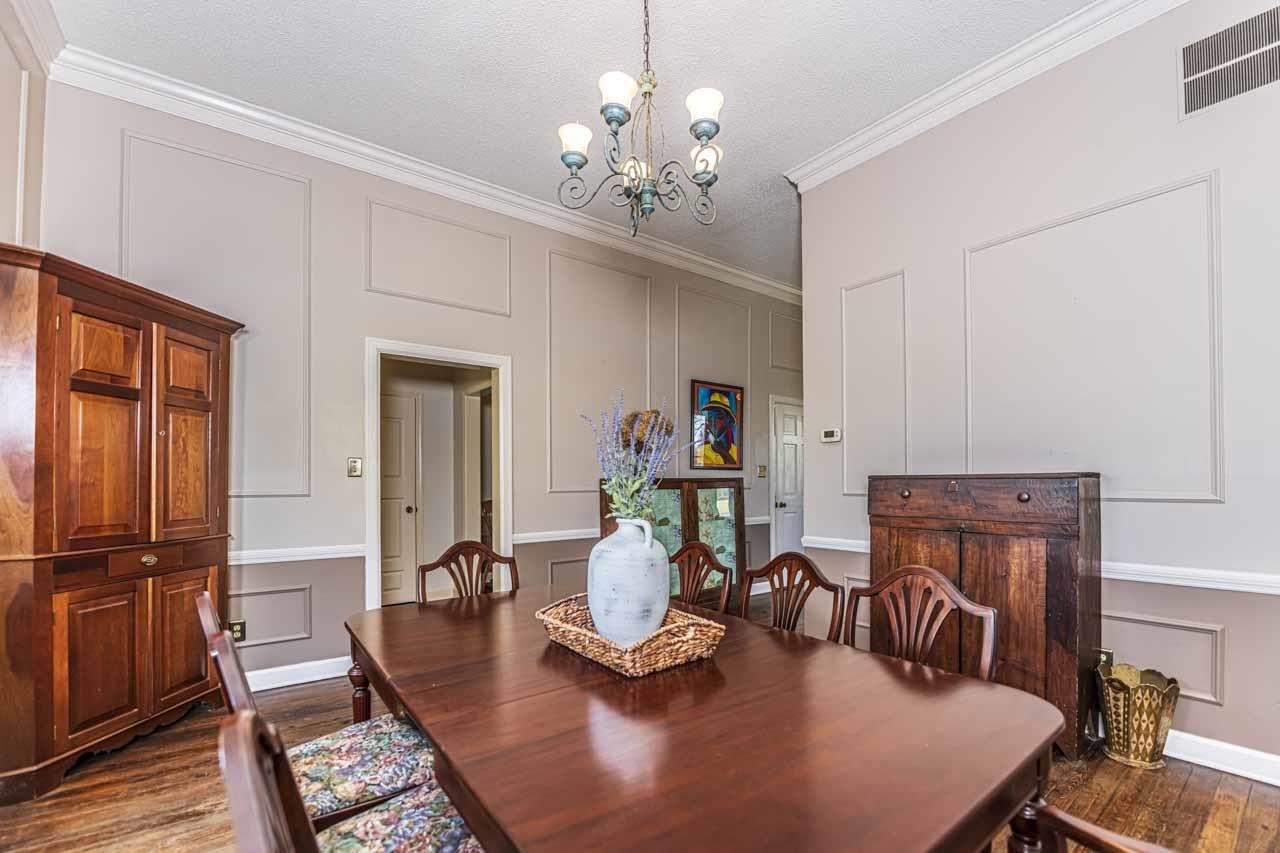 6746 Old Millington Road Millington, TN 38053 - Photo 14 of 40 Dining room featuring a decorative wall, dark wood-style flooring, suspended lighting, ornamental molding, and a textured ceiling
