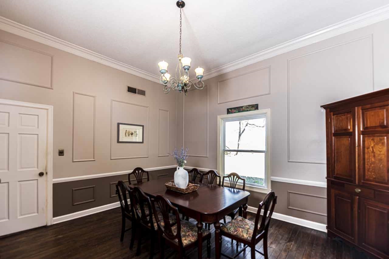 6746 Old Millington Road Millington, TN 38053 - Photo 15 of 40 Dining room featuring a decorative wall, dark wood-style floors, hanging lights, and crown molding