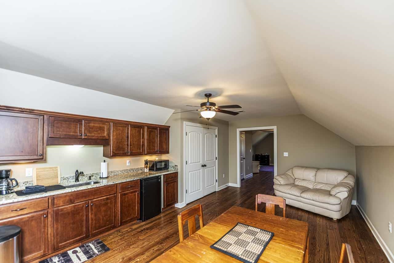 6746 Old Millington Road Millington, TN 38053 - Photo 40 of 40 Kitchen featuring dark wood-style floors, a ceiling fan, vaulted ceiling, dark wood finish cabinets, and open floor plan