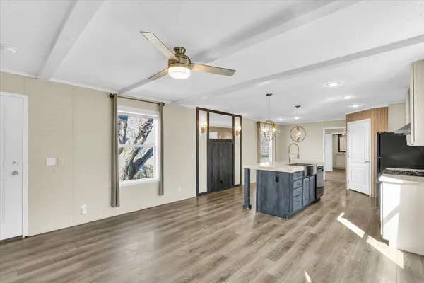 a view of a kitchen with furniture a flat screen tv and wooden floor