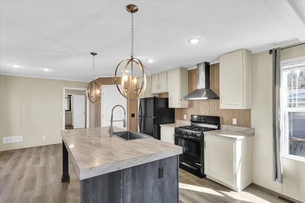 a kitchen with kitchen island stainless steel appliances a sink a stove and a center island