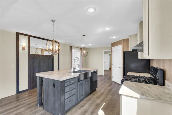 a kitchen with stainless steel appliances granite countertop wooden cabinets a stove and a sink