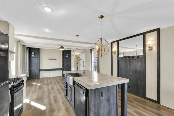a kitchen with a sink a counter top space and stainless steel appliances
