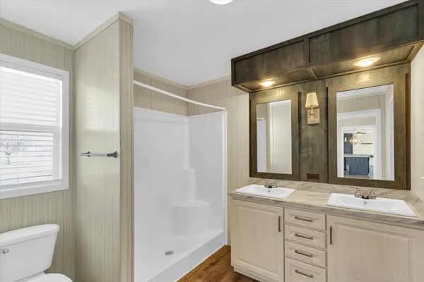 a bathroom with double vanity and a mirror