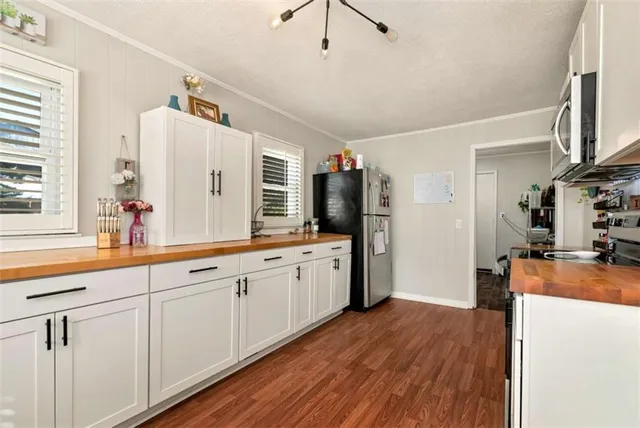 a large kitchen with a lot of counter space and wooden floor