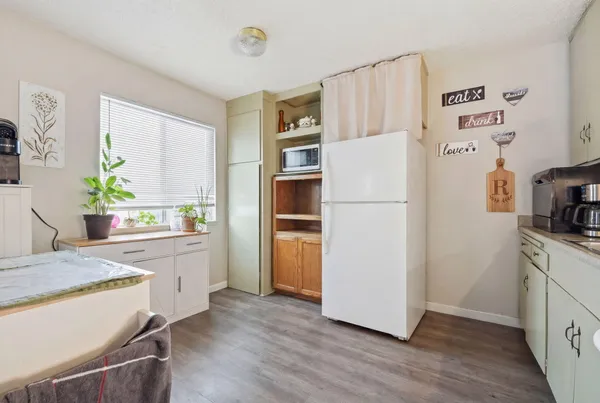 a kitchen with a refrigerator a stove a sink and wooden floor