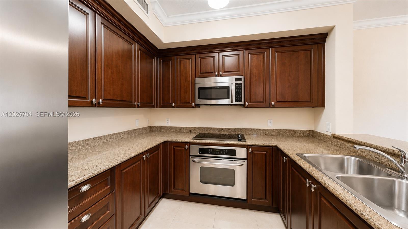 4106 Renaissance Way, Unit 106 Boynton Beach, FL 33426 - Photo 3 of 14 a kitchen with stainless steel appliances granite countertop a sink stove and microwave