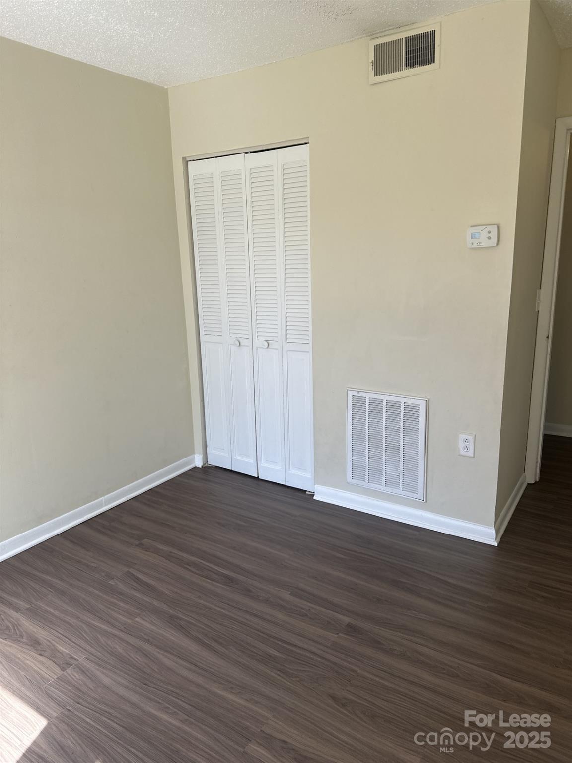 4816 Spring Lake Drive, Unit E Charlotte, NC 28212 - Photo 11 of 14 a view of an empty room with wooden floor and a window