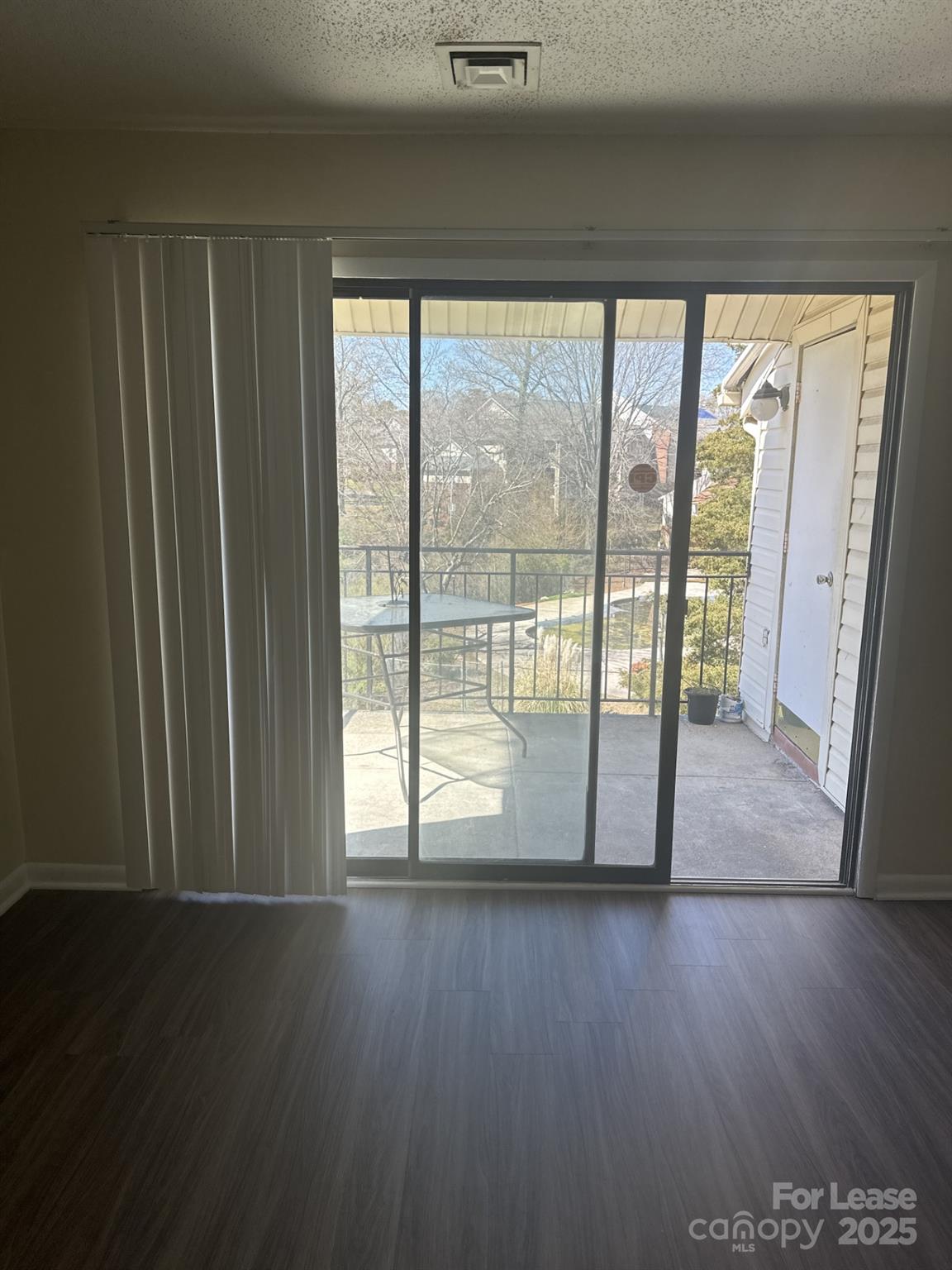 4816 Spring Lake Drive, Unit E Charlotte, NC 28212 - Photo 6 of 14 a view of empty room with wooden floor and fan