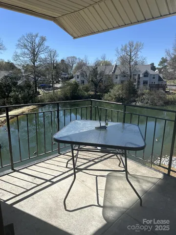 a view of a backyard with a table and chair under an umbrella