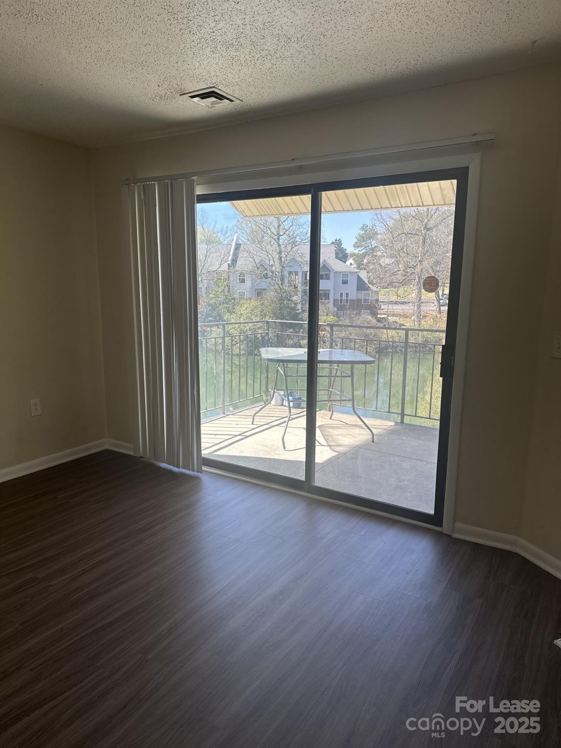 4816 Spring Lake Drive, Unit E Charlotte, NC 28212 - Photo 9 of 14 a view of empty room with wooden floor and fan