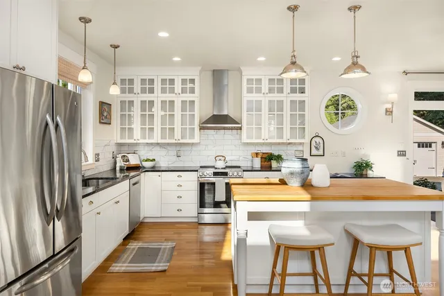 a kitchen with stainless steel appliances granite countertop a sink a stove and a refrigerator