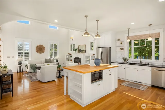 a large kitchen with kitchen island a large counter top space a sink stainless steel appliances and cabinets
