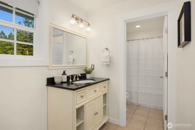 a bathroom with a granite countertop sink a mirror and a shower