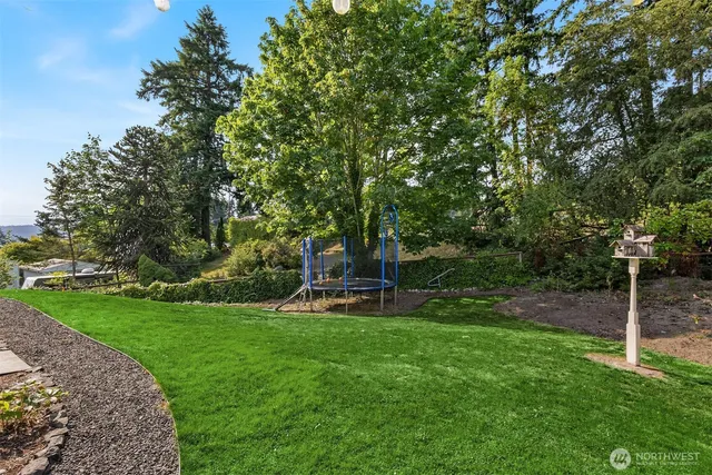 a view of a backyard with table and chairs and wooden fence