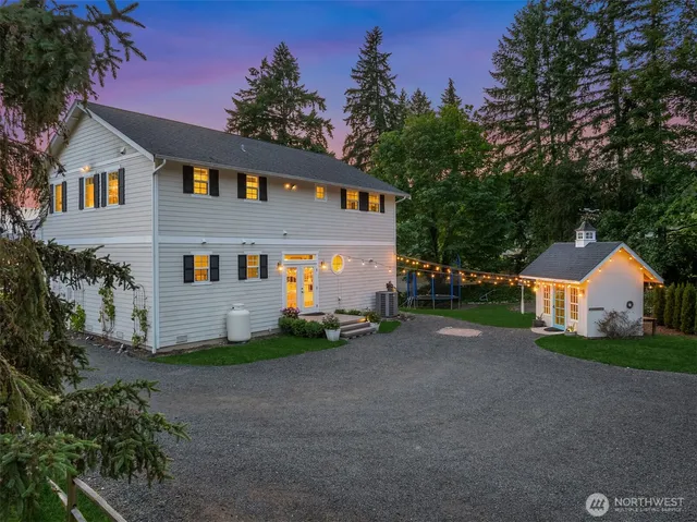 a front view of house with yard and trees in the background