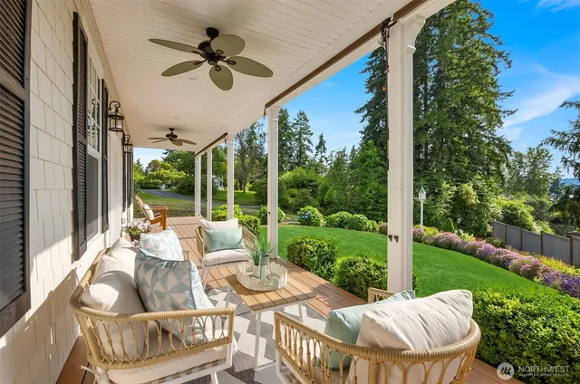 a view of an outdoor dining space with a table chairs and a floor to ceiling window