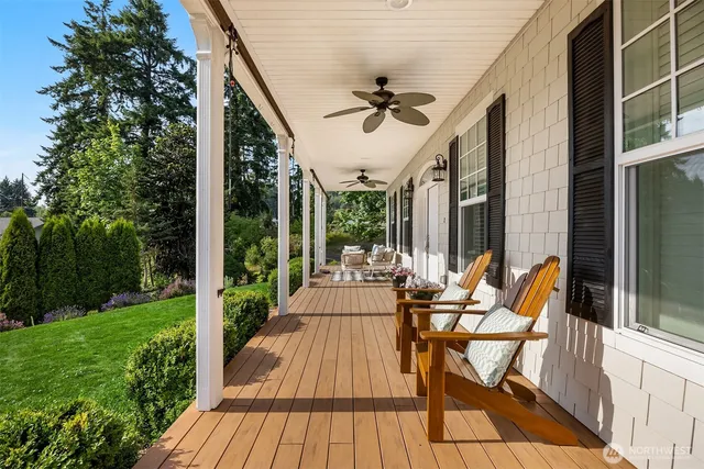 a view of patio with table and chairs potted plants with wooden floor and fence