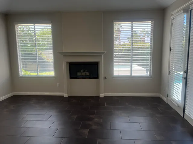 a view of an empty room with a window and a fireplace