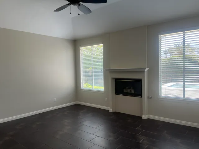 an empty room with windows and fireplace