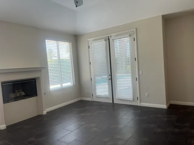 a view of an empty room with a window and a fireplace