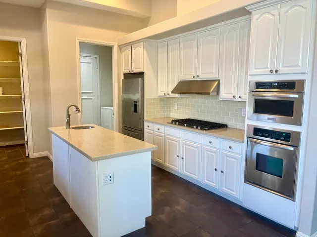 a kitchen with stainless steel appliances granite countertop a stove and a refrigerator