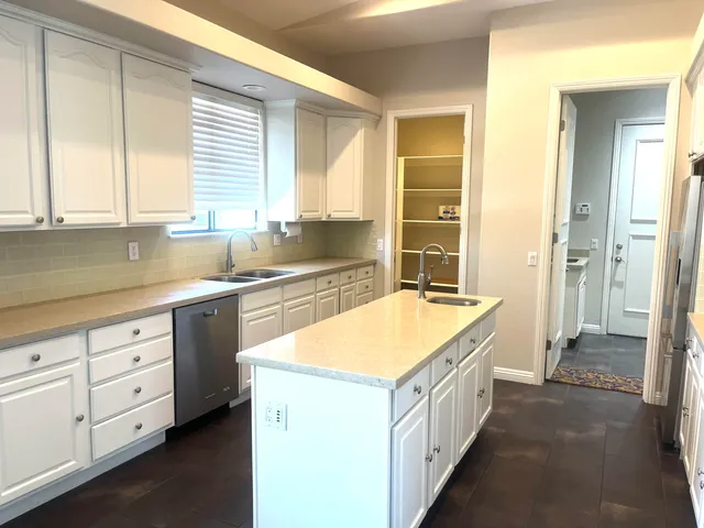 a bathroom with a granite countertop sink and a bathtub