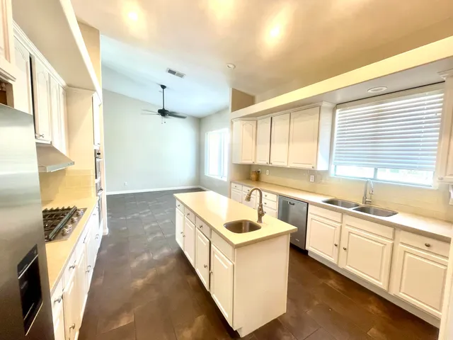 a large white kitchen with a window a sink and a counter top space
