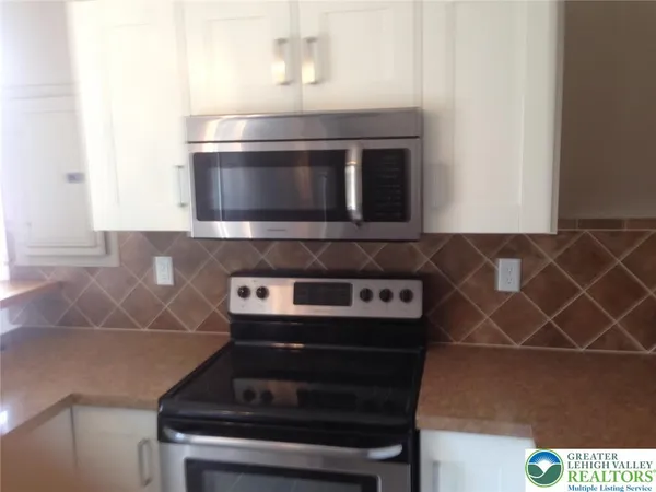 a stove top oven sitting inside of a kitchen